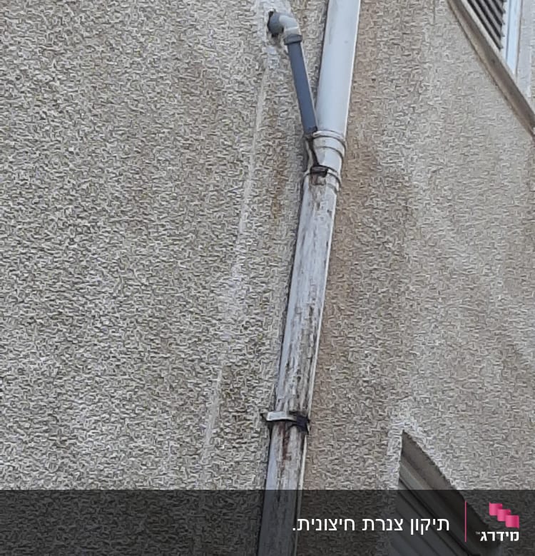 צינור מים חיצוני מחובר לקיר בניין